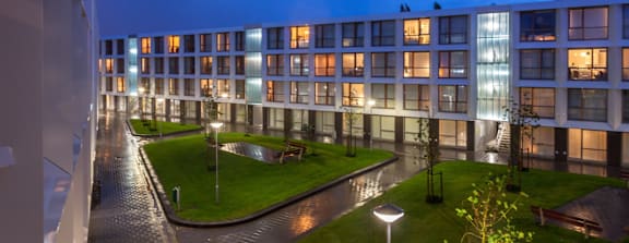 A modern building with a well-lit courtyard at night.