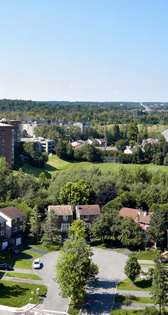 A large island in the middle of a lake surrounded by trees in autumn colours.at Baseline Apartments, Ottawa, ON