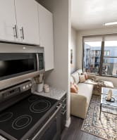 a kitchen with white cabinetry and a black and white counter top at Link Apartments® NODA 36TH,North Carolina,28206