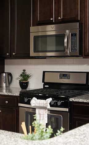 A kitchen with a stove top oven and microwave above it.
