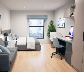 a bedroom with a bed and a desk in a room