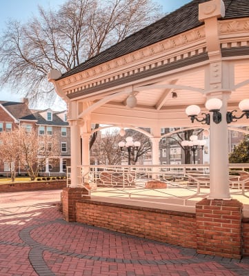 a gazebo in front of a large brick building