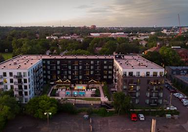 an aerial view of an apartment building with a pool in the courtyard