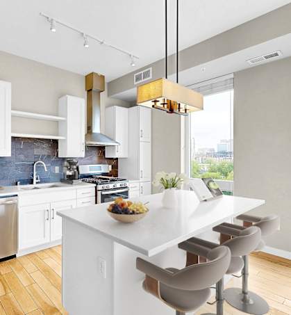 A modern kitchen with a white island and stainless steel appliances.