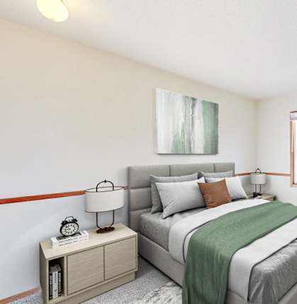 A bedroom with a bed, nightstand, and a window.