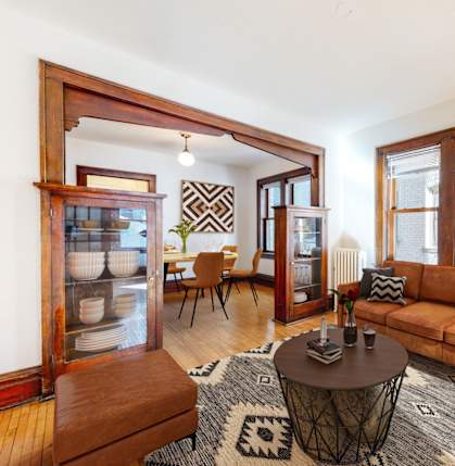 A living room with a brown couch, a coffee table, and a rug.