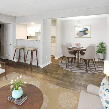 a living and dining room area with a table and chairs and a kitchen in the background at Planters Trace, South Carolina