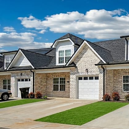 A row of houses with garages and driveways.