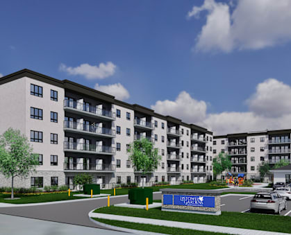 A modern apartment complex with a blue sign in front.
