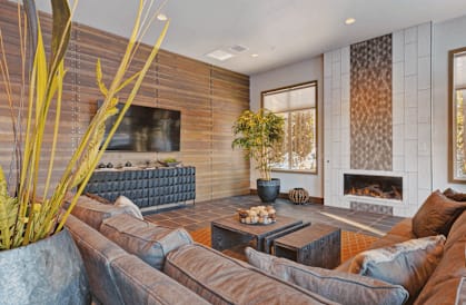 A living room with a brown couch and a fireplace.
