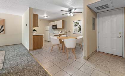 a dining room with a table and chairs and a kitchen