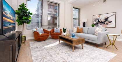 a living room with a couch and chairs and a tv