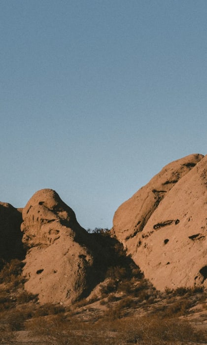 a cluster of rocks in the desert against a blue sky