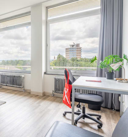 A room with a bed, desk, and chair.
