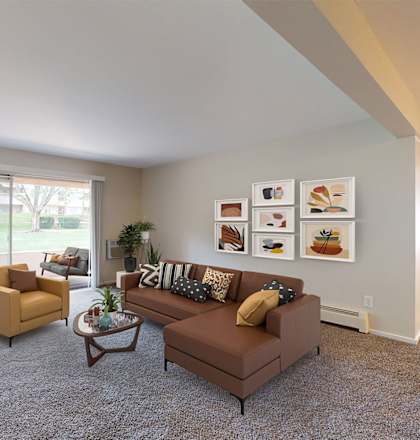 a living room with a brown couch and two yellow chairs