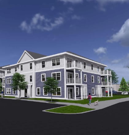 A large, modern building with a parking lot in front.