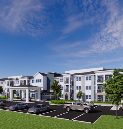 A large white building with a parking lot in front.