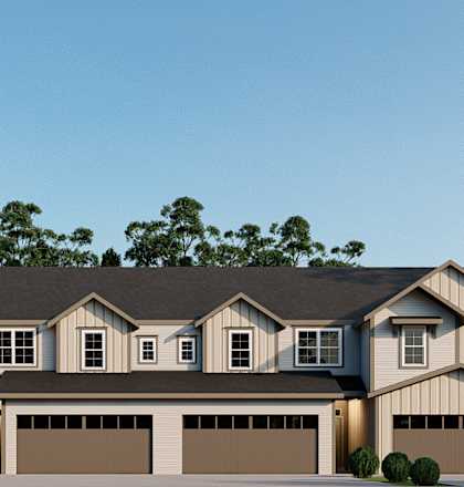 A modern house with a large front yard and two garages.