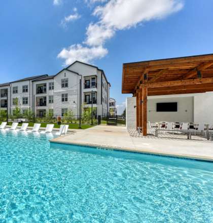 an outdoor swimming pool with apartments in the background