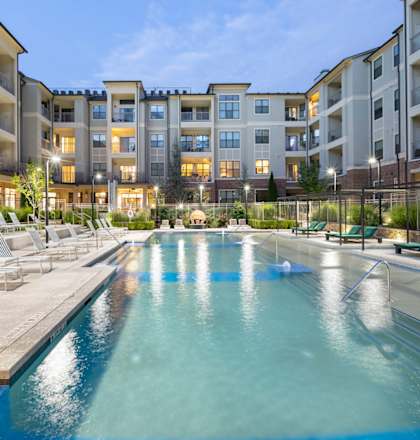 an apartment building with a swimming pool and lounge chairs at The Hendrix, Atlanta, GA, 30329