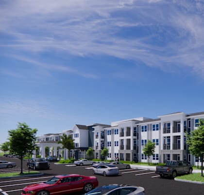 A modern apartment complex with a parking lot in front.