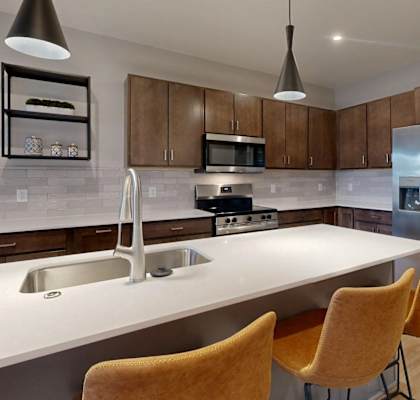 A kitchen with a white countertop and a stainless steel refrigerator. at Ardor on the Bluffs South Loop Residences Apartments, Bloomington, 55425