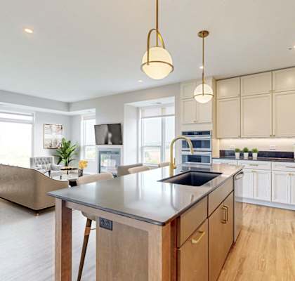 A modern kitchen with a large island and wooden cabinets. at Ardor on the Bluffs South Loop Residences Apartments, Bloomington, 55425