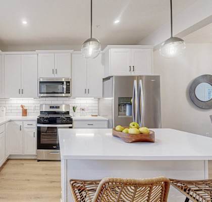 a large kitchen with white cabinets and a white counter top