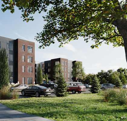 A modern apartment complex with a parking lot in front.