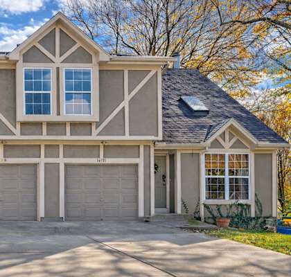 A large house with a grey roof and a grey garage door.
