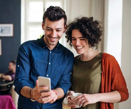 a man and a woman looking at a cell phone