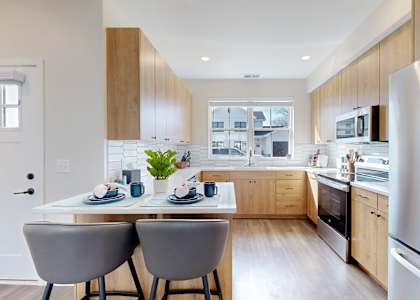 A modern kitchen with a dining table and chairs.