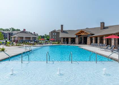 A large swimming pool with a few people in it.
