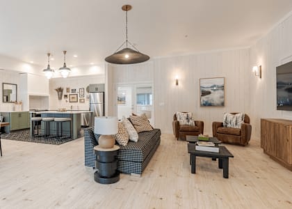 A living room with a couch, chairs, and a coffee table at Falls Creek Apartments in Idaho, 83815