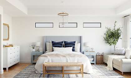 a bedroom with white walls and a bed with blue pillows