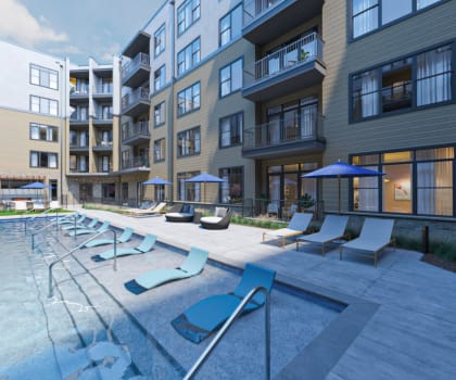 an outdoor pool with lounge chairs and umbrellas in front of an apartment building