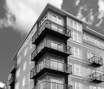 a black and white photo of a tall apartment building
