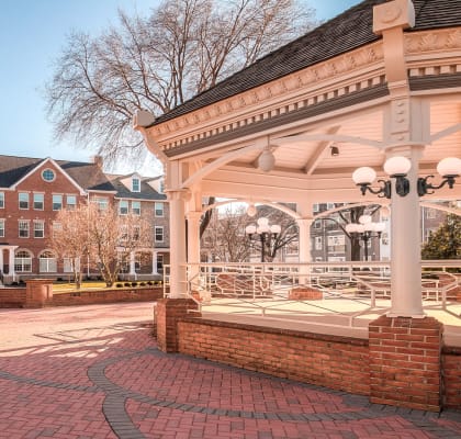 a gazebo in front of a large brick building