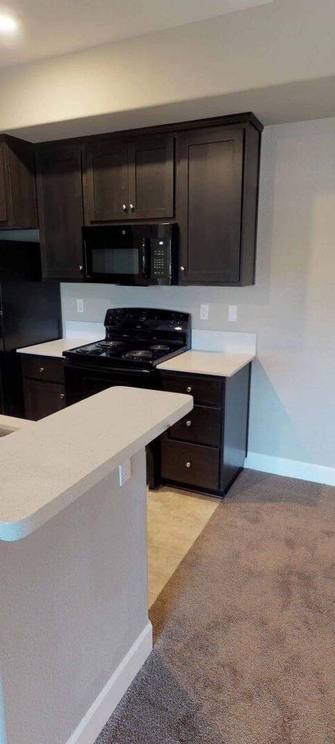 a kitchen with black cabinets and a counter with a sink at Edgewater, Pittsburg, CA 94565