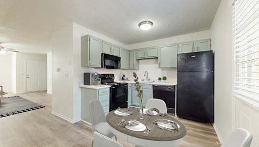 A kitchen with a table set for four.