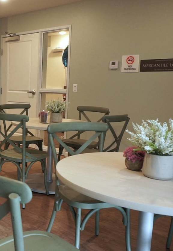 a dining room with tables and chairs and a kitchen