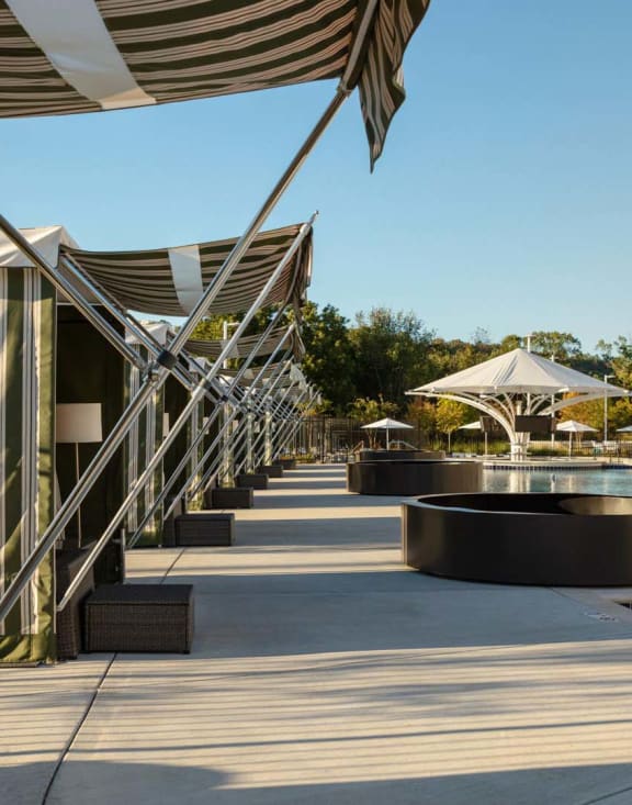 a resort with a pool and umbrellas at Esplanade District Apartments, Little Rock