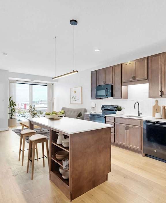 A modern kitchen with wooden cabinets and stainless steel appliances.at The Rosalyn | Affordable 55+ Apartments in Bloomington, Bloominton Minnesota