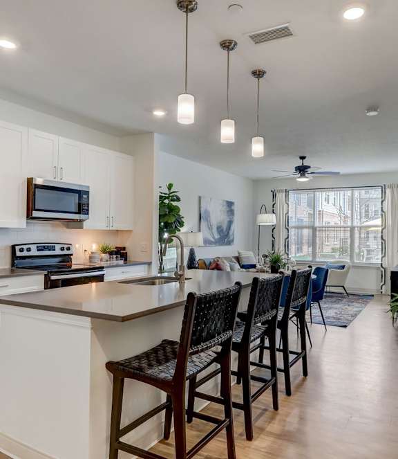 A modern kitchen with a large island and bar stools.