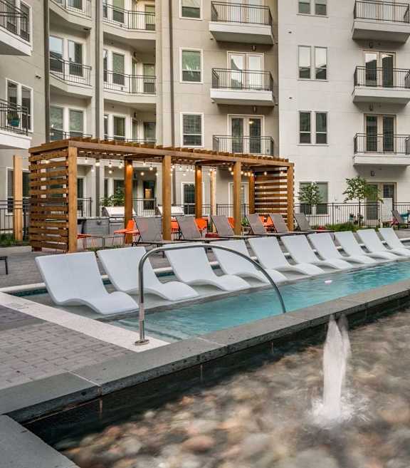 A pool with a fountain in the middle of it.