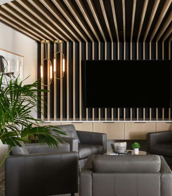 a living room with couches and a tv on the wall at Esplanade District Apartments, Little Rock