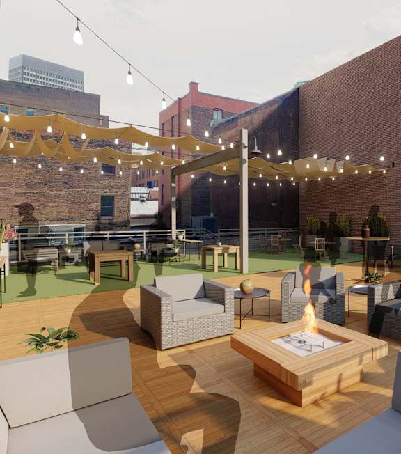 A patio with a table and chairs is surrounded by brick buildings. at Lofts at 629, Ohio, 44114
