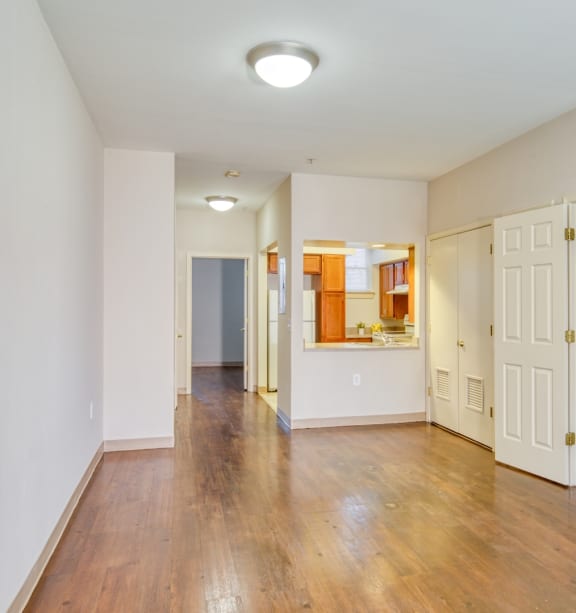 a renovated living room with a hard wood floor and white walls at North Market South Carroll, Frederick, MD