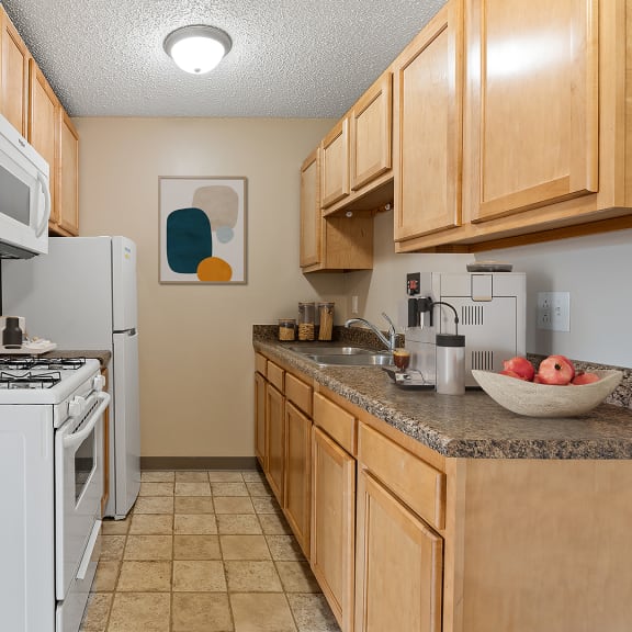 our apartments have a kitchen with white appliances and wood cabinets