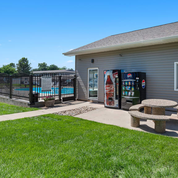 a picnic table in front of a house with a gas station